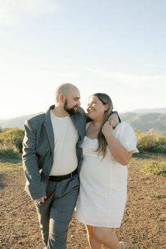 a man and woman are walking in the dirt