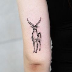 a woman's arm with a small tattoo of an antelope