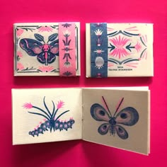 three small paintings are on display against a bright pink background, one has a butterfly and the other is an insect