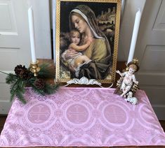 a table topped with candles and a painting next to a candle holder on top of a table