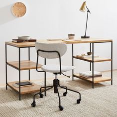 a desk with a chair, lamp and bookshelf next to it on the floor