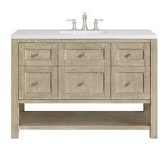 an image of a bathroom vanity with drawers and two faucets on the sink