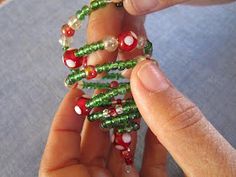 a person is holding some beads in their hand and they are making something out of them