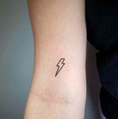 a woman's arm with a small lightning tattoo on the left side of her arm