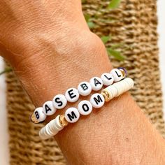 For all my baseball moms! Create your own custom stackable bracelet in your team colors or your personal favorite color combo.  This listing is for two bracelets. Select the color beads and make sure you write the SIZE and either GOLD or BLACK letter beads in the personalization box.  To determine size take a flexible measuring tape or string and measure around your wrist. Then add .5" to get your bracelet size. The most common size is Medium Adult 6.75"  Bracelet is made with elastic (stretchy) cord, 6mm heishi beads, gold plated (brass filled) disks and letter beads.  Please note that all sales are FINAL.  Excited to help you with your bracelet stacks! Be sure to message me with any questions!  Thank you for supporting my small business. White Stretch Bracelet With Letter Print, Customizable White Wristband For Everyday, Casual White Beaded Bracelets For Personalized Gift, White Casual Stretch Bracelet For Mother's Day, Casual White Stretch Bracelet For Mother's Day, White Casual Name Bracelet For Personalized Gift, White Team Spirit Stretch Bracelet As Gift, Customizable White Wristband For Game Day, Casual White Name Bracelet For Personalized Gift