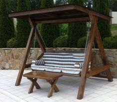 a wooden swing chair with cushions on it