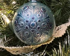 an ornament hanging from a christmas tree with some twine on the bottom