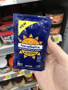 a hand holding up a bag of marmalade in front of a store shelf