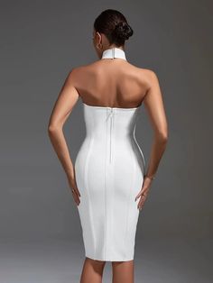 a woman in a white dress with her back to the camera