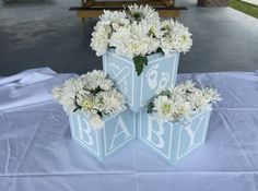 two vases with white flowers on a table