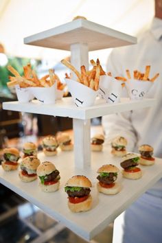 a white tray topped with mini sandwiches and fries