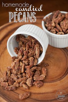 homemade candied pecans in small white dishes on a wooden tray with text overlay