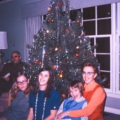 a family sitting in front of a christmas tree