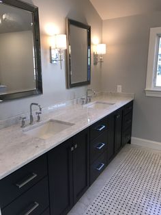 a bathroom with double sinks and two mirrors