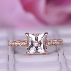 an engagement ring with a princess cut diamond in the center on top of a keyboard