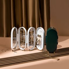 three white clocks sitting on top of a table next to a green box and chain