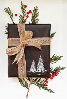 a christmas present wrapped in brown paper and tied with a bow, surrounded by evergreen branches