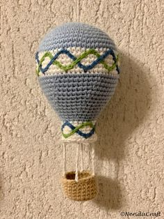 a crocheted hot air balloon hanging on the wall