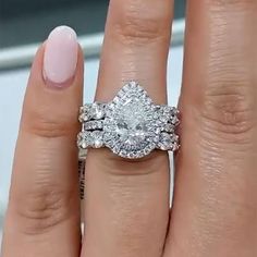 a woman's hand with two engagement rings on top of her finger and the ring is