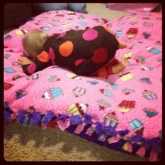 a small child laying on top of a pink bed