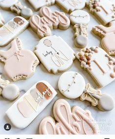 some decorated cookies are on a table with the words baby shower written in white and pink