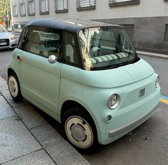 the small car is parked on the side of the street