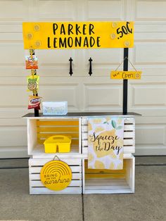 an outdoor lemonade stand with yellow and white crates