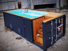 a man swimming in an outdoor pool made out of shipping containers