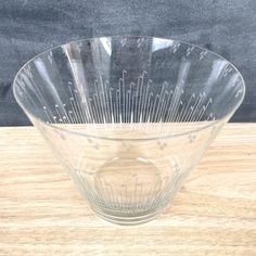 a clear bowl sitting on top of a wooden table