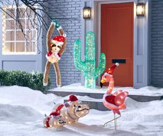 christmas decorations in front of a house with flamingos