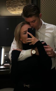 a man and woman taking a selfie in front of a mirror with their cell phone