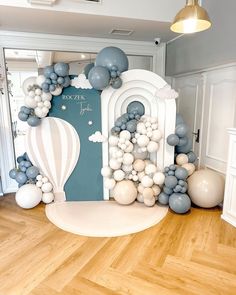 a balloon arch is decorated with blue and white balloons