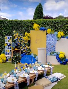 a table set up with blue and yellow decorations