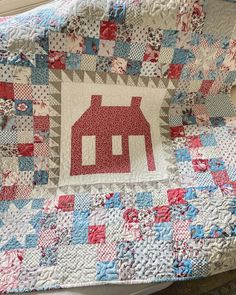 a quilt with a red house on it