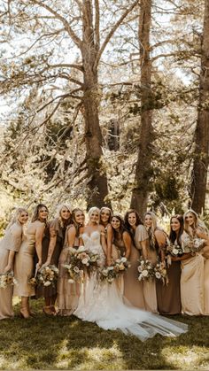 a group of women standing next to each other in front of trees