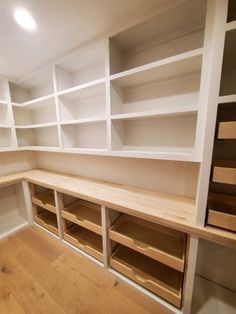 empty white shelves in a room with wood floors