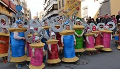 some people are standing in the middle of a street with many different colored hoses