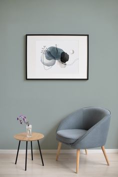 a chair and table in a room with a painting on the wall