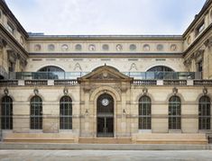 an old building with many windows and a clock on the front door is seen in this image