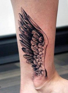 a woman's foot with a tattoo on it that has an angel wings design