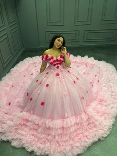 a woman in a pink dress is talking on her cell phone while wearing a flowered gown