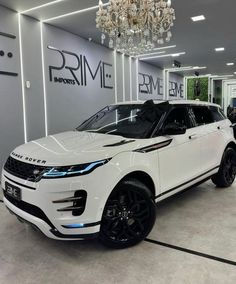 a white range rover parked in a showroom