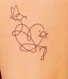 a small tattoo on the back of a woman's thigh that has a bird flying over it