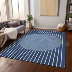 a living room with a blue rug on the floor and a couch in the background