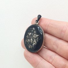 An Austro Hungarian antique locket crafted from a solid silver base with a black enamel front. The locket opens and closes well and as it should. On the face there are floral patterns with numerous seed pears, one seed pearl is modern so has been replaced at some point. There are some chips and scratches to the enamel which i have tried to capture in the photos so please check through them all. Beside this and for its age it is still in good antique condition. Internally the glass is still in place on the left hand side. The locket weighs approx. 17.25 g and has foreign hallmarks on the loop. Please check out the other items in my shop. Be sure to view all photos and videos for condition and read the titles and descriptions. Sizes are in the latter photos.  Don't hesitate to send me a mess Antique Black Locket Jewelry, Victorian Black Medallion Jewelry, Black Victorian Medallion Jewelry, Antique Black Oval Cabochon Jewelry, Antique Oval Jewelry With Black Enamel, Antique Oval Black Enamel Jewelry, Collectible Black Locket Jewelry, Antique Black Engraved Jewelry, Antique Black Enamel Jewelry