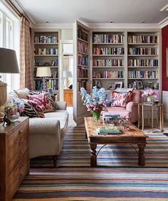 a living room filled with lots of furniture and bookshelves full of books on shelves