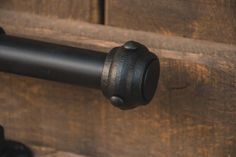 a close up of a black metal handle on a wooden door