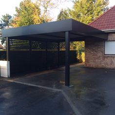 a black covered parking lot next to a brick building