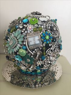 a clock sitting on top of a table covered in lots of beads