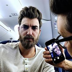 a man is taking a selfie with his cell phone while on an airplane or plane